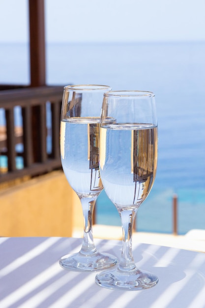 Due bicchieri di champagne in terrazza con vista mare