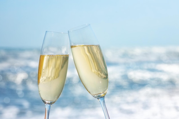 due bicchieri di champagne sulla spiaggia del mare