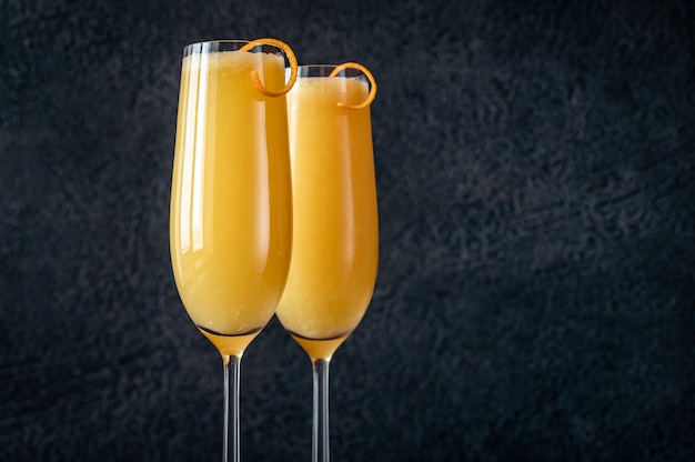 Due bicchieri di cocktail Buck's Fizz sul tavolo nero