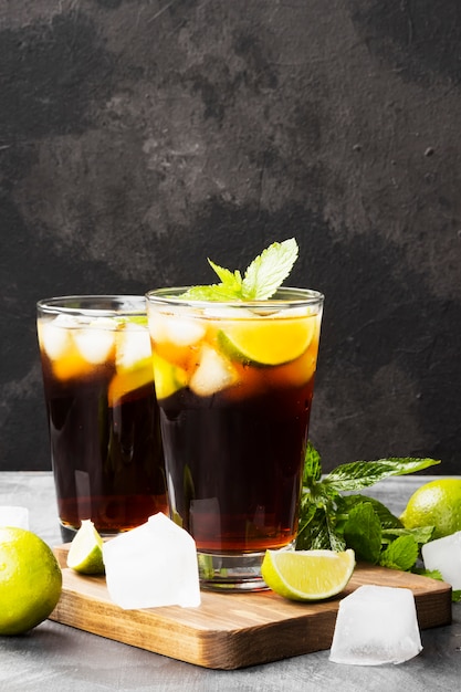 Due bicchieri di cocktail Cuba Libre su uno sfondo scuro