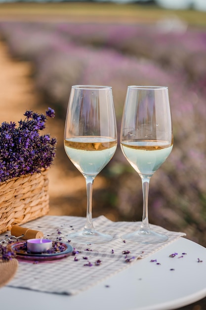 Due bicchieri di vino bianco in un campo di lavanda in Provance Fiori viola sullo sfondo