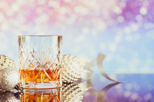 Due bicchieri di whisky o bourbon con decorazioni natalizie su un leggero bokeh