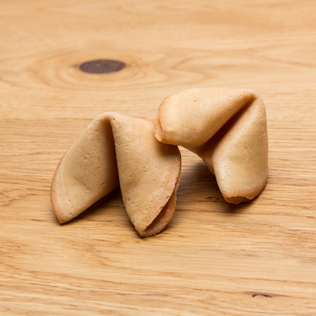 Due biscotti della fortuna su uno sfondo di tavolo in legno. Scattata in Studio con una 5D mark III.