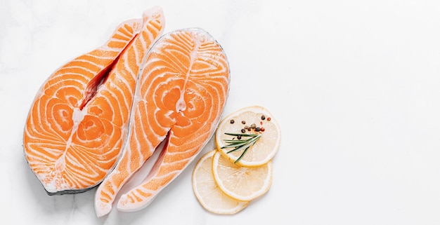 Due bistecche di salmone crudo su una superficie di marmo bianco il concetto di una cena sana per due da bistecche di salmone bistecche di salmone fresco