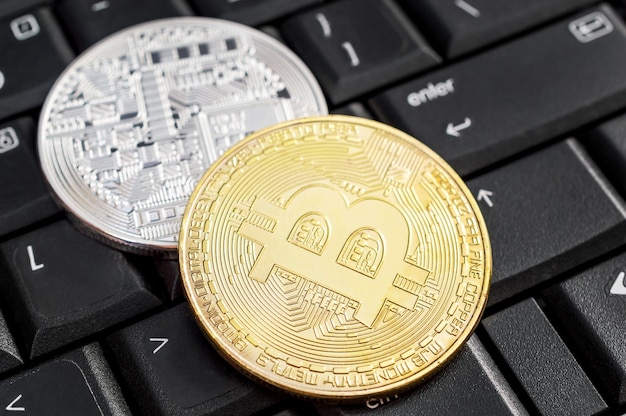 Due bitcoin sulla tastiera del laptop Primo piano Concetto di business ed e-commerce