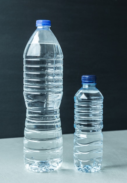 Due bottiglie di acqua di plastica sfondo nero