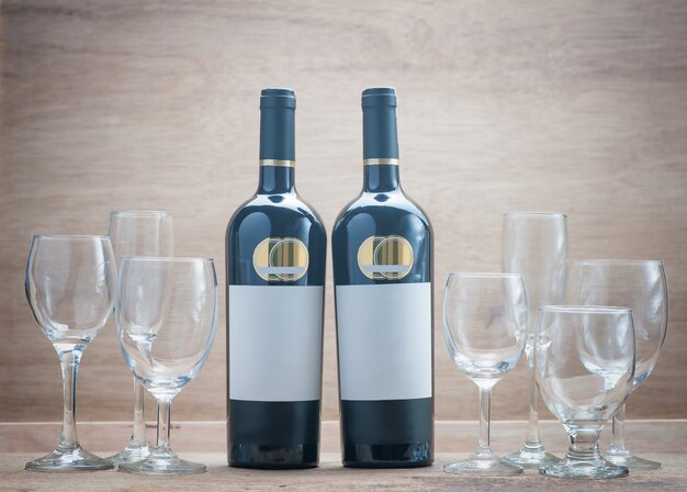 Due bottiglie di vino e Set Clear Wineglass su fondo in legno con still life