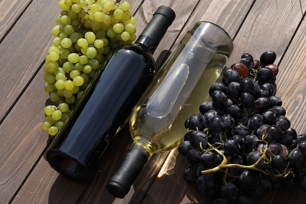 due bottiglie di vino rosso e bianco con uva