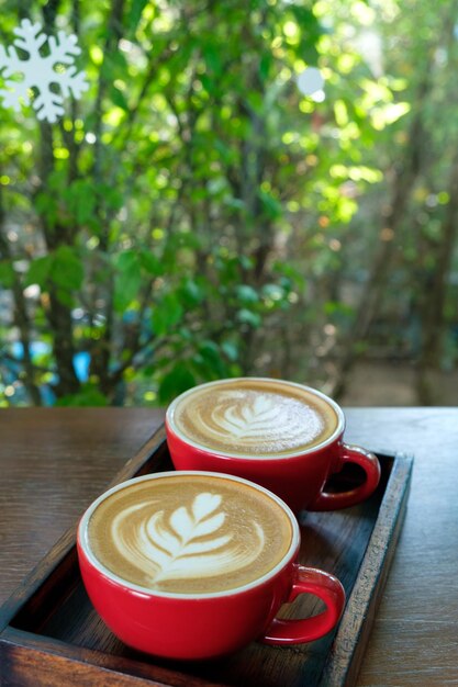 Due caffè latte art in tazza rossa