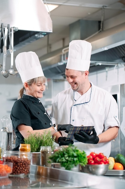 Due chef discutono del menu nella cucina di un ristorante o di un hotel.