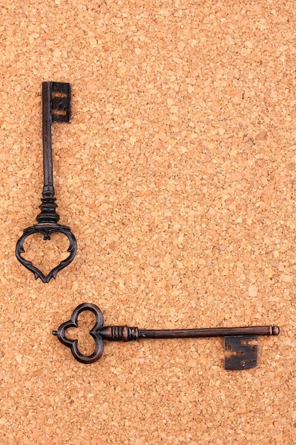Due chiavi antiche su sfondo di sughero