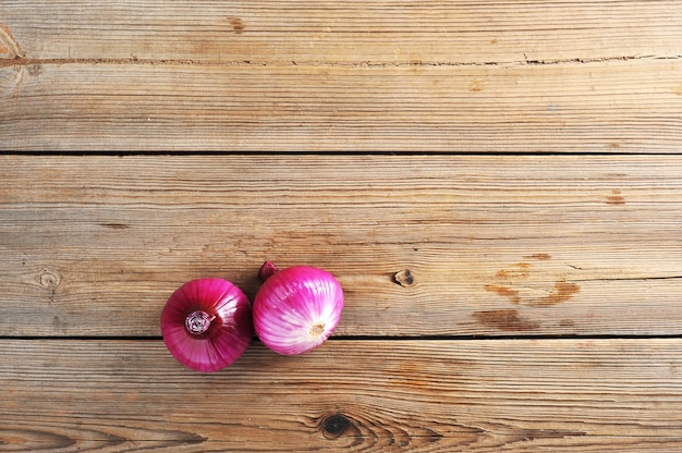 Due cipolle rosse su fondo di legno rustico