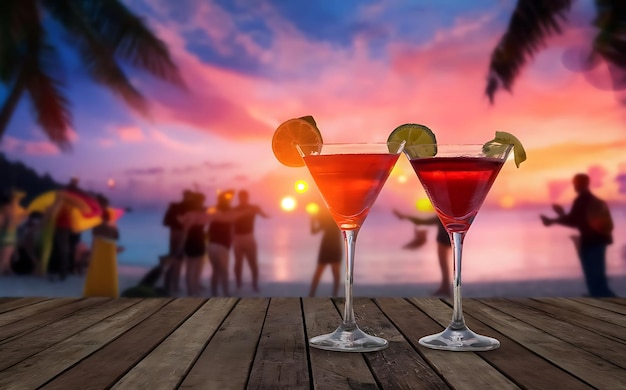 Due cocktail con festa sull'oceano sulla spiaggia sfocata e cielo colorato al tramonto sullo sfondo di lusso