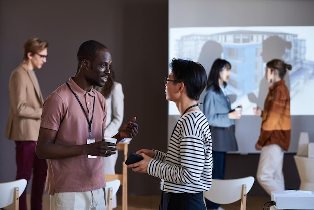 Due colleghi che si incontrano al seminario e condividono i contatti tra loro durante il networking