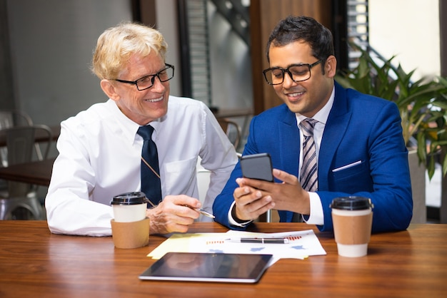 Due colleghi che utilizzano il telefono sull&#39;intervallo per il caffè