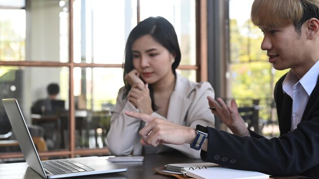 Due colleghi di lavoro che lavorano consigliandosi a vicenda