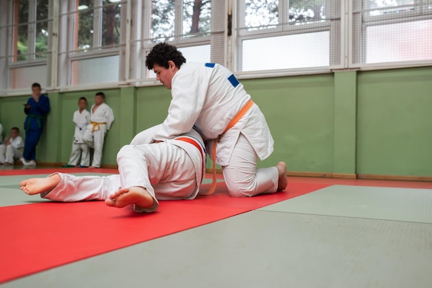 Due combattenti di judo che mostrano abilità tecniche mentre praticano arti marziali in un fight club I due uomini in forma in uniforme combattono il concetto di competizione di atleta di arti di allenamento di karate Focus selettivo