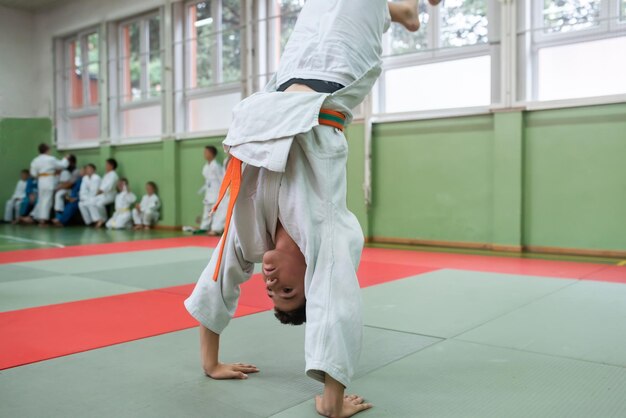 Due combattenti di judo che mostrano abilità tecniche mentre praticano arti marziali in un fight club I due uomini in forma in uniforme combattono il concetto di competizione di atleta di arti di allenamento di karate Focus selettivo