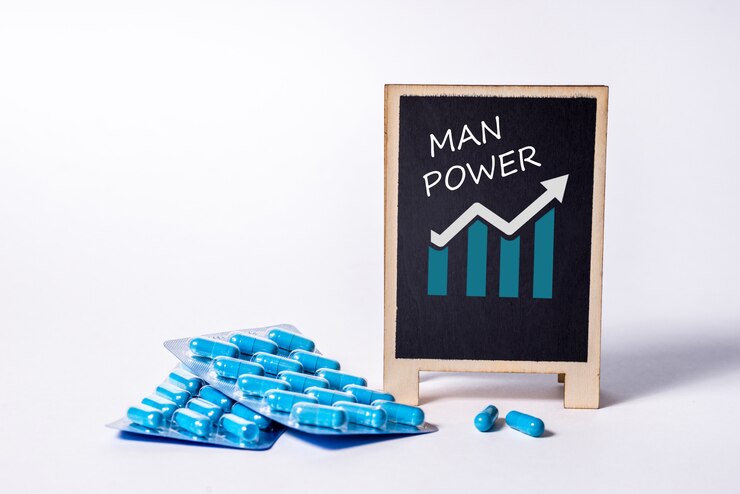Due confezioni di capsule blu e la parola man power su una lavagna. Pillole per la salute e l'energia sessuale degli uomini. Concetto di erezione, potenza. Trattamento di infertilità e impotenza maschili.