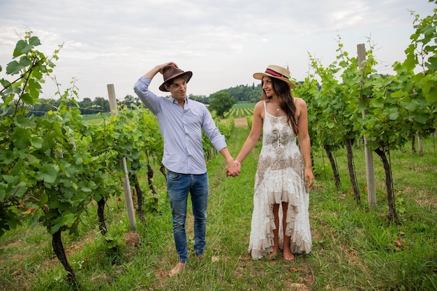 Due contadini innamorati si tengono per mano mentre sono in un momento romantico di vigna