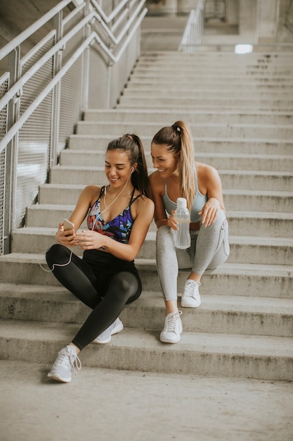 Due corridori femminili alla ricerca di smart phone un periodo di riposo dopo il jogging