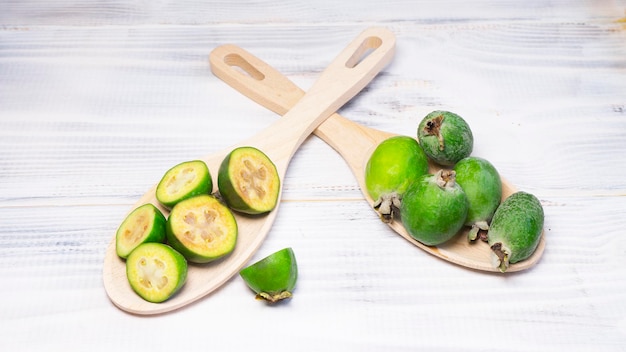 Due cucchiai di legno con frutti di feijoa