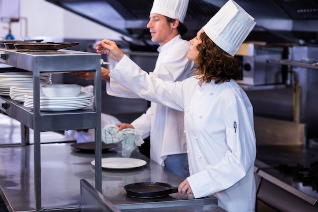 Due cuochi che lavorano alla stazione di ordine in una cucina