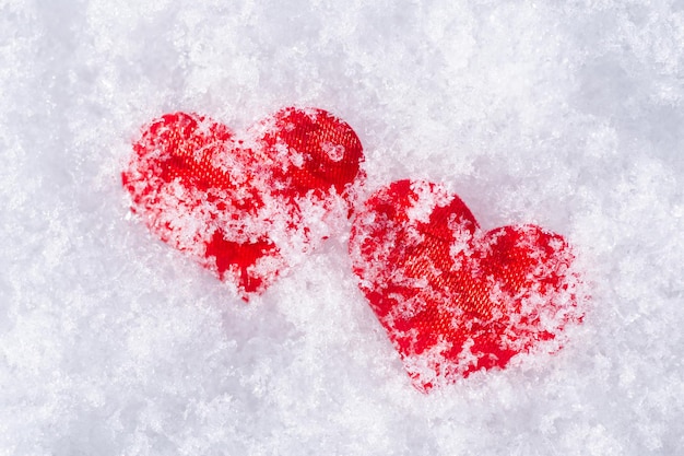 Due cuori rossi nella neve bianca. Concetto di amore, relazione, San Valentino