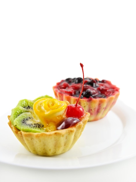 Due cupcakes con frutta e gelatina, su bianco