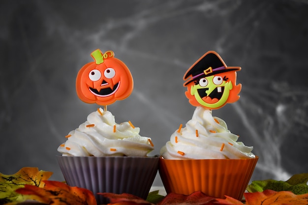 Due cupcakes di Halloween con decorazioni di zucca e strega.