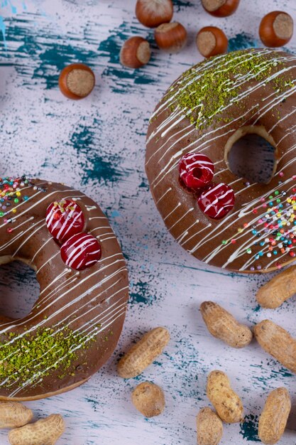 Due deliziose ciambelle al cioccolato con noci sane poste su un tavolo di pietra.