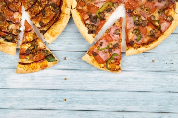 Due diverse deliziose pizze grandi su uno sfondo di legno blu.