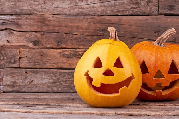 Due divertenti zucche di Halloween su tavole di legno.