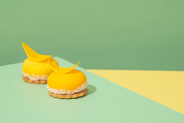 Due dolcetti in miniatura di colore giallo posti su un tavolo blu e giallo