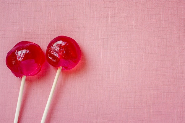 Due dolci caramelle su sfondo rosa