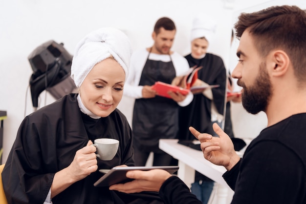 Due donne adulte con asciugamani sulle teste scelgono l&#39;acconciatura.