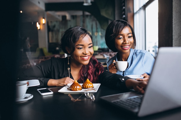 Due donne afroamericane con laptop e pranzo