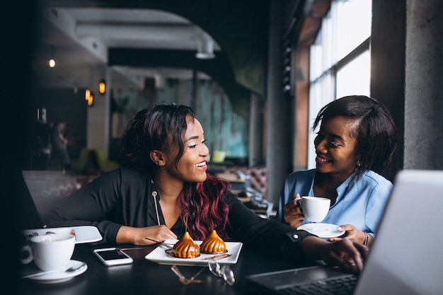 Due donne afroamericane con laptop e pranzo