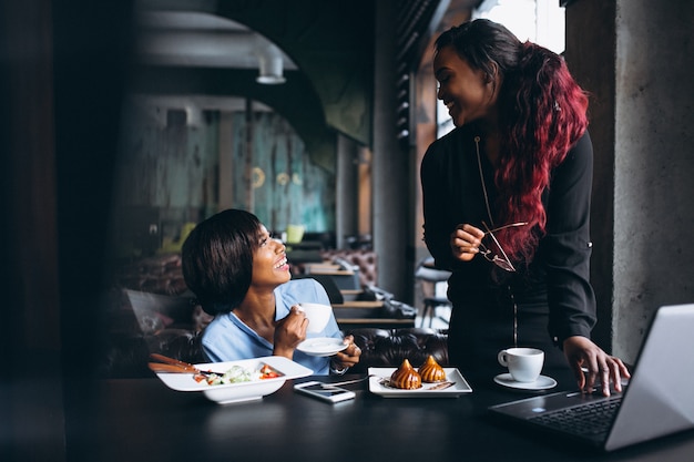 Due donne afroamericane con laptop e pranzo