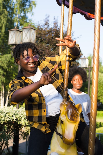 Due donne afroamericane felici in un parco durante una giostra in estate