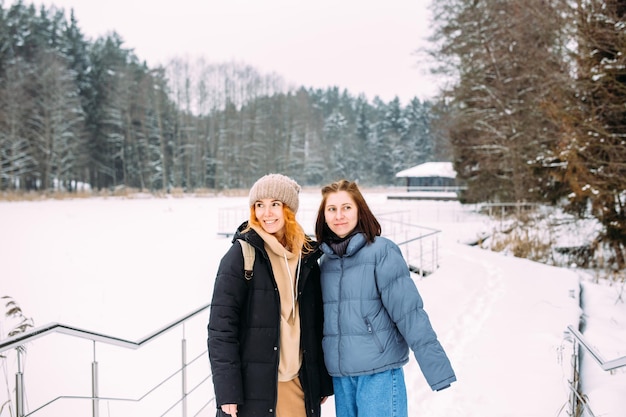 Due donne amiche in inverno nella natura nel parco in una giornata fredda