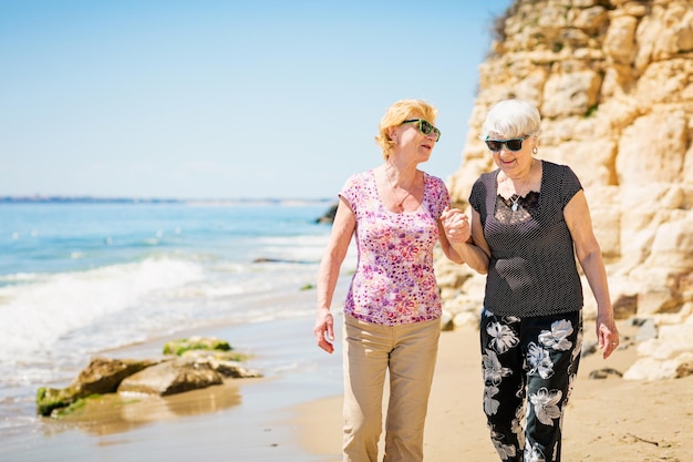 Due donne anziane stanno camminando lungo la costa rocciosa