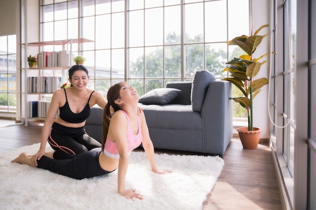 Due donne asiatiche che addestrano fitness e yoga a casa