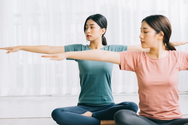 Due donne asiatiche praticano la meditazione a casa