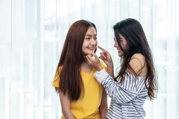 Due donne asiatiche toccando il mento e giocando insieme. Persone e stile di vita. Orgoglio LGBT