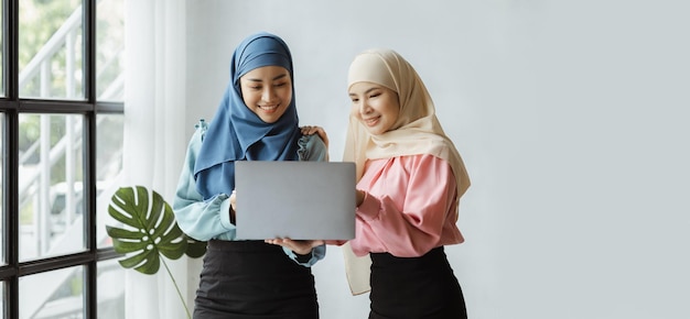 Due donne asiatiche vestite di hijab stanno facendo brainstorming insieme in una sala conferenze per una startup gestita da una giovane donna di talento Il concetto di gestione gestisce l'azienda di leader femminili per far crescere l'azienda