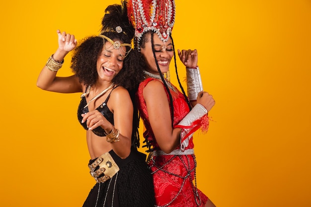 Due donne brasiliane amiche in abiti da carnevale che ballano