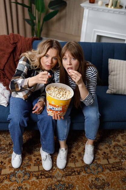 Due donne carine di età diverse si concentrano a guardare la TV