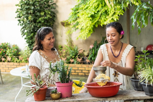 Due donne che macinano mais per cibo tradizionale