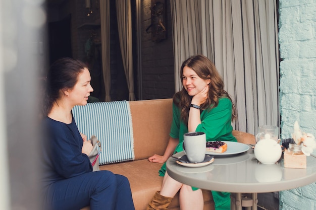 Due donne che parlano e bevono caffè al bar